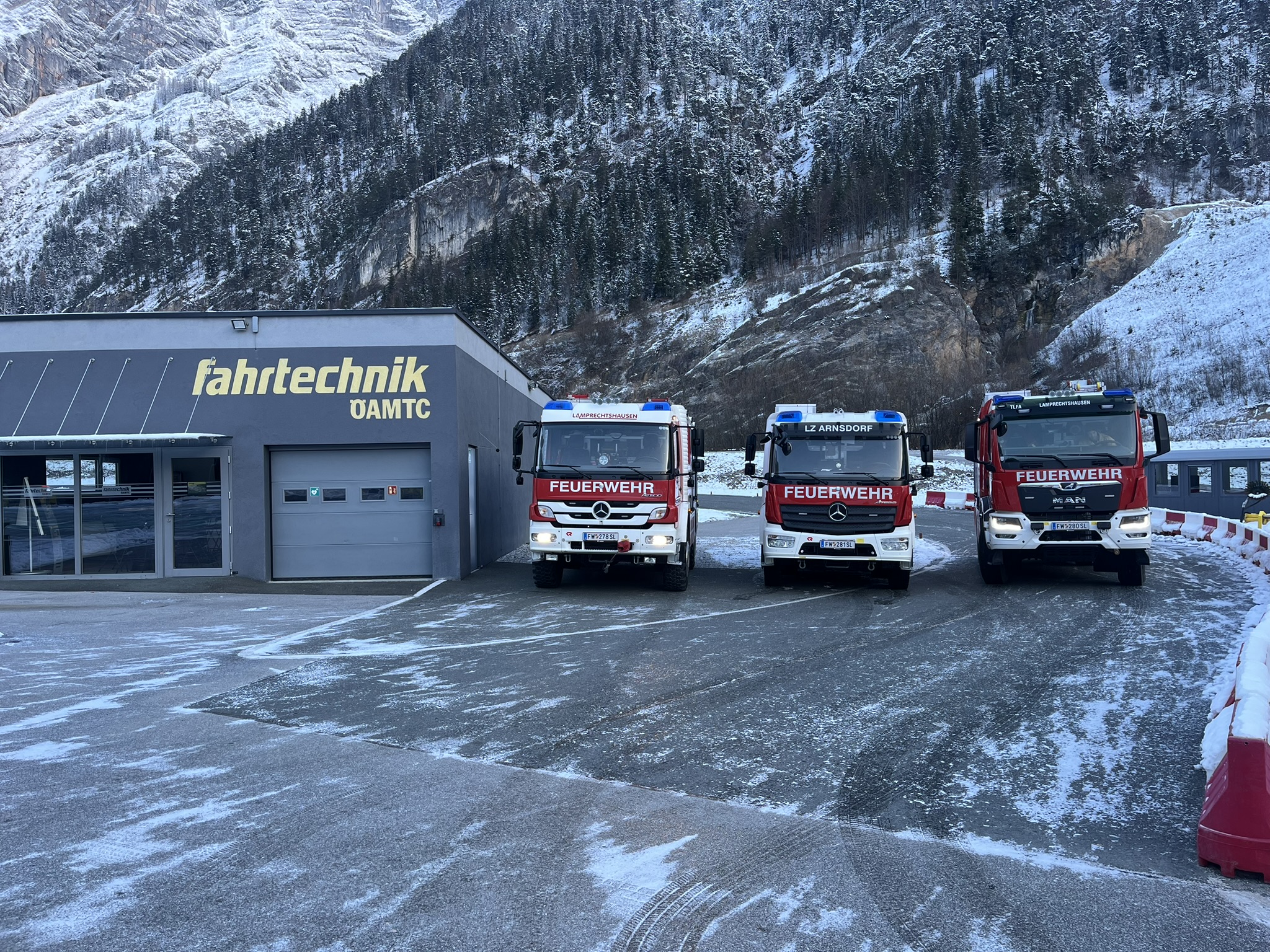 Die drei Fahrzeuge der Feuerwehr Lamprechtshausen neben dem Gebäude des Fahrsicherheitszentrums